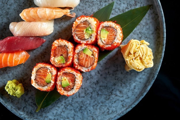 Californian sushi roll set with salmon in tobiko caviar and various sushi. Sushi with salmon, tuna, shrimp.