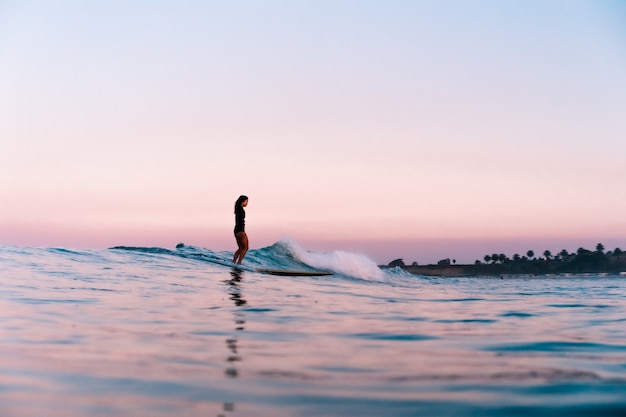 Foto californië meisje surfen onder een prachtige suikerspin zonsopgang