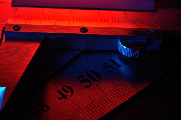 Photo caliper and metal rulers illuminated in red and blue closeup