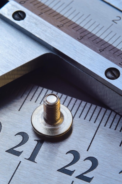 Photo caliper and nuts with a bolt a metalwork measuring tool lies on the background of metal rulers closeup