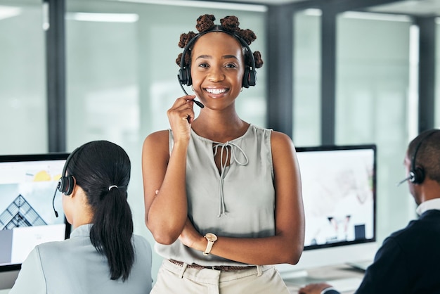 Call center agent leider staat met gekruiste armen en kijkt trots en draagt een headset in een kantoor met collega's Portret van een glimlachende vrouwelijke klantenservice die werkt en er zelfverzekerd uitziet