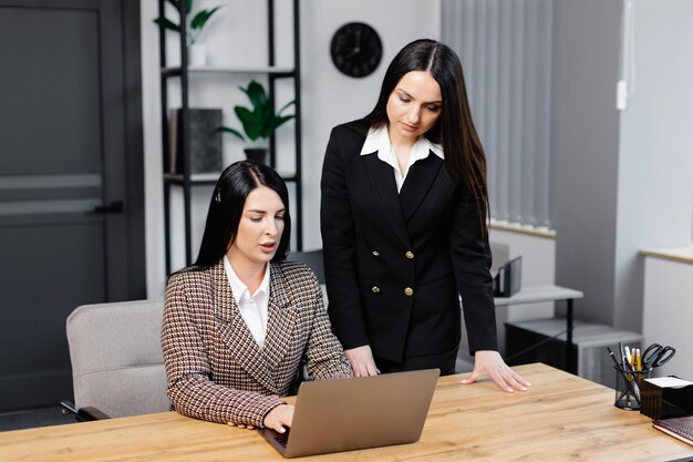 Call center agent with headset working on support hotline in modern office Two young attractive women are working in the office