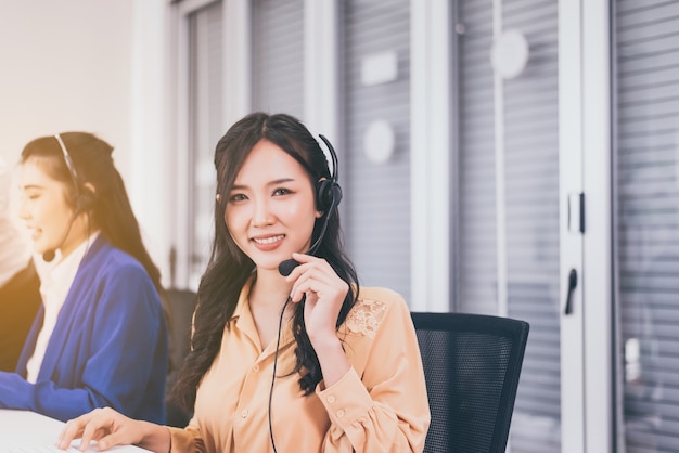 Call center asian team worker together at office,Smiling employees woman operator working with headset