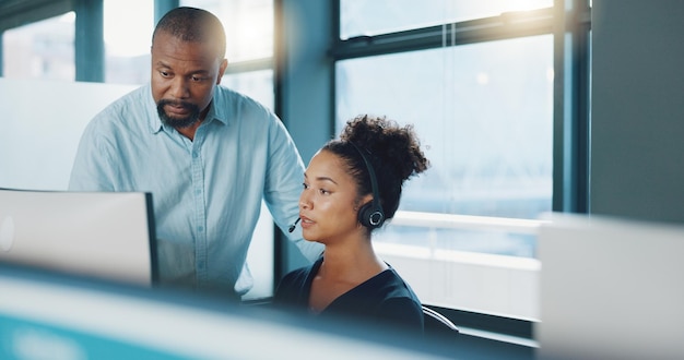 call center black man and training woman telemarketing intern and crm customer service consultant on computer software in office agency business people sales mentor and coaching for tech solution