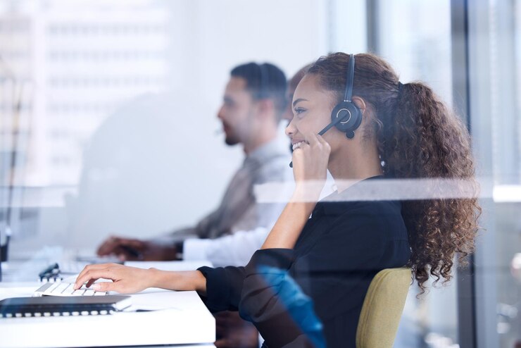 Photo call center customer service and glass with a black woman consultant working in her telemarketing office contact us crm and communication with a female consulting at work using a headset