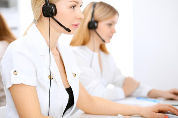 Call center. Focus on beautiful woman in headset.