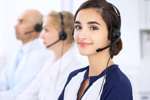 Call center. Focus on beautiful woman in headset.