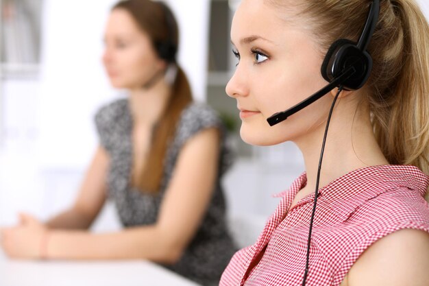 Call center. Focus on beautiful woman in headset.