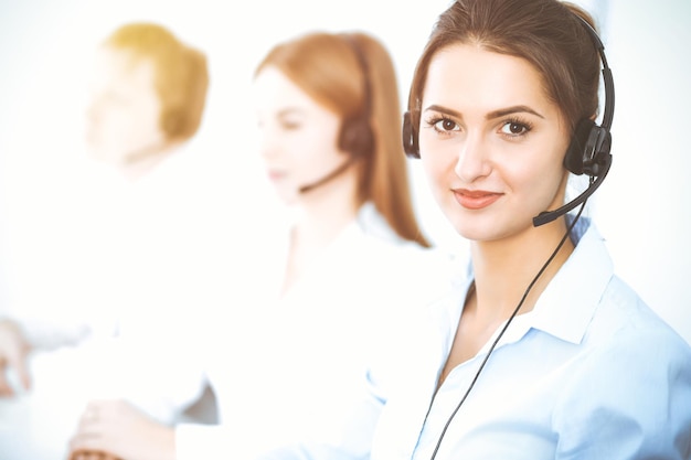 Foto operatori di call center. concentrarsi sulla bella donna d'affari utilizzando l'auricolare.