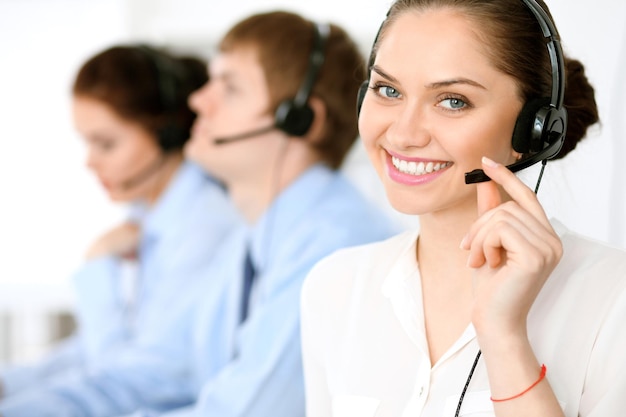 Call center operators. Focus at brunette business woman in headset