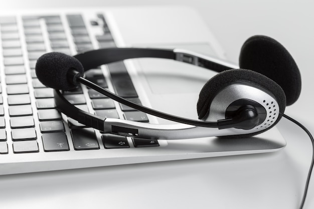 Call center support concept. headset on keyboard computer laptop