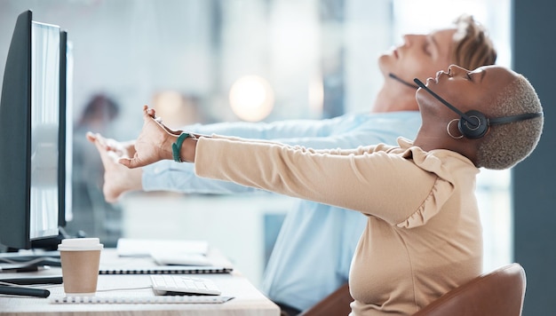 Foto team di call center e stretching per lavoro nel servizio clienti contattaci o attività di telemarketing in ufficio consulente uomo e donna in braccio o allungamento della mano per alleviare lo stress calmo dal computer