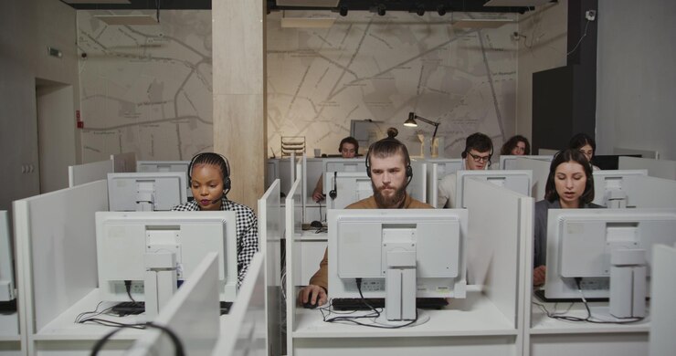 Photo call center with workers in microphones with headphones talking with clients