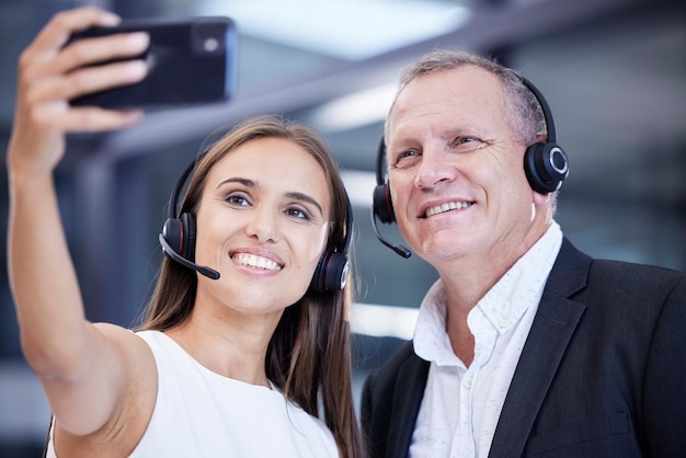Call center work and friends phone selfie smile at corporate customer service office in Australia Workplace friendship and smartphone photograph with senior man and young woman working together