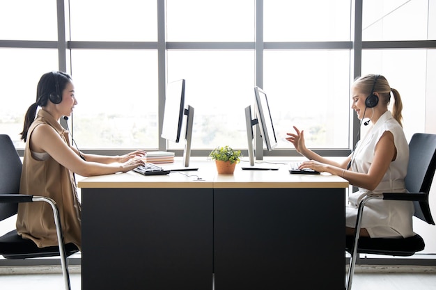 Call center worker accompanied by team. Smiling of customer support operator at work.