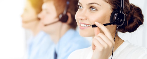 Callcenter. Diverse klantenservicemedewerkers in headsets op het werk op kantoor. Bedrijfsconcept.