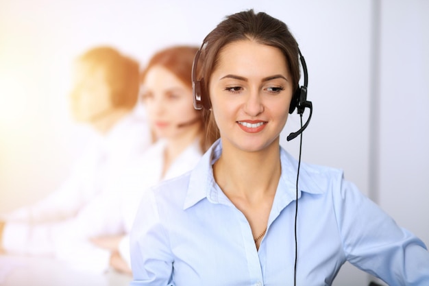 Callcenter. Focus op mooie zakenvrouw met behulp van headset in zonnig kantoor.