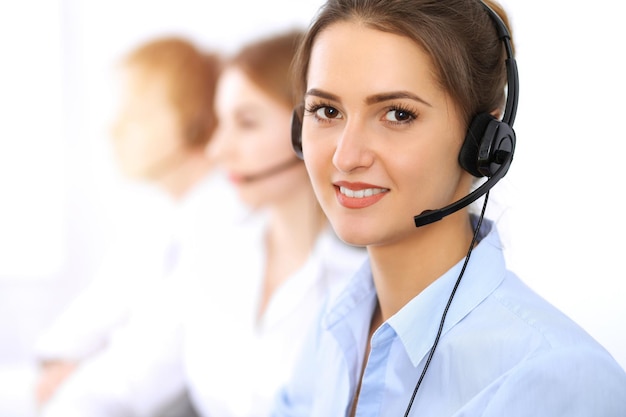 Callcenter. Focus op mooie zakenvrouw met behulp van headset in zonnig kantoor.