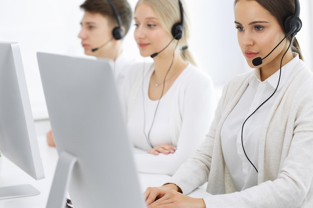 Callcenter Groep operators aan het werk Focus op vrouwelijke receptioniste in headset bij klantenservice