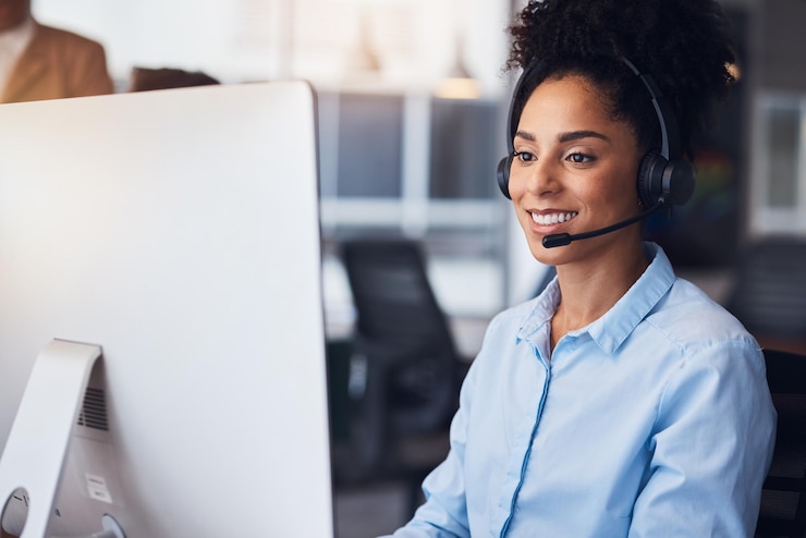 Foto callcenter klantenservice en computer met een zwarte vrouw die in haar communicatiebureau werkt neem contact met ons op telemarketing en overleg met een vrouwelijke werknemer op het werk met behulp van een headset