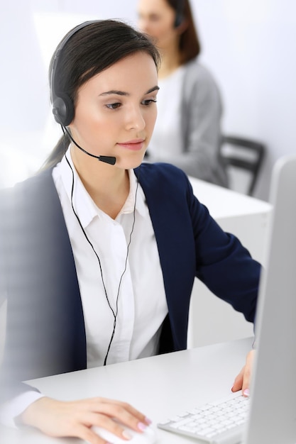 Callcenter Mooie vrouw receptioniste zit in headset bij klantenservice kantoor