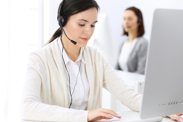 Callcenter Mooie vrouw receptioniste zit in headset bij klantenservice kantoor