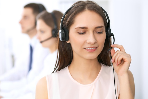 Callcenter operators. Focus op jonge mooie zakenvrouw in hoofdtelefoon.