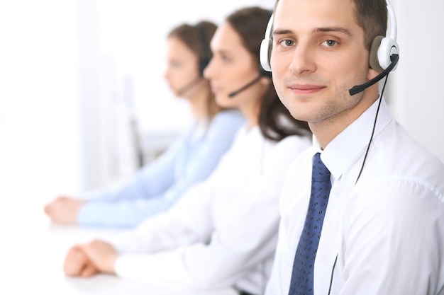 Callcenter operators. Focus op zakenman in headset tijdens het raadplegen van klanten.