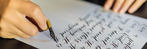 Foto le mani del calligrafo scrivono una frase su una frase biblica di carta bianca sull'amore che inscrive ornamentale