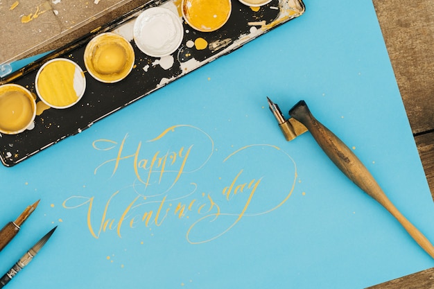 Photo calligraphy and inscription. happy valentines day, on a blue background with gold ink.