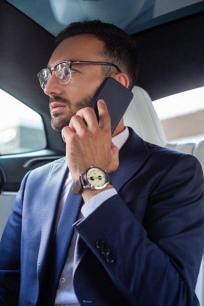 Calling his secretary. Successful young businessman wearing hand watch calling his secretary