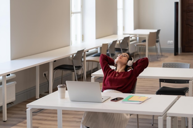 Calm asian girl student with closed eye listen music rest from exam preparation at university campus