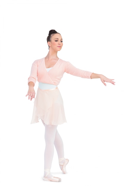 Calm attractive ballerina posing with her arms extended