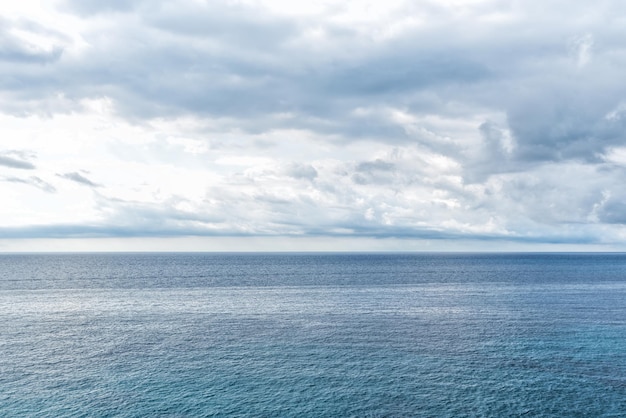 극적인 폭풍우 구름이 있는 잔잔한 푸른 바다