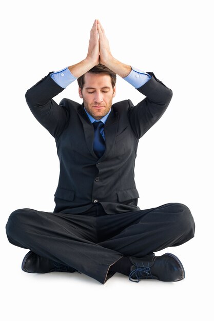 Calm businessman sitting in lotus pose with hands together