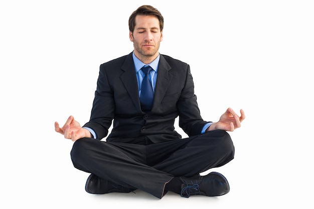 Calm businessman sitting in lotus pose