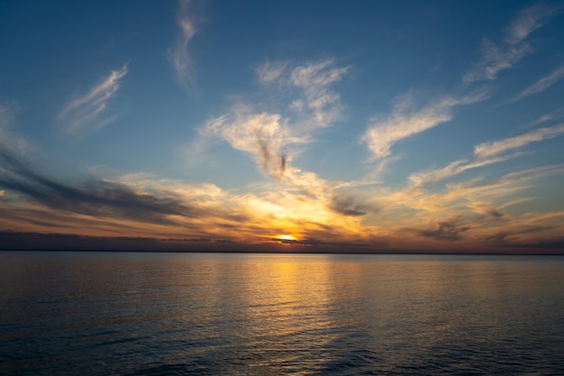 Calm on the coast The sky in the evening Water Sunset sky on the coast Golden hour Sky and clouds Feather cloud The sun went down below the horizon Evening sky background Sunrise landscape