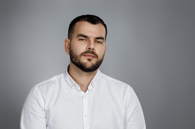 Calm handsome bearded man poses in studio