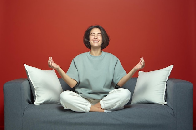 Photo calm happy young girl meditate with mudra hands gesture eyes closed breathing fresh air sitting on