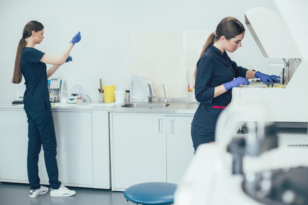 Calm lab technician loading blood samples into centrifuge machine