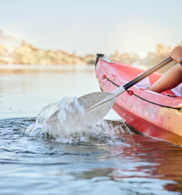 Foto sport acquatico sul lago calmo e donna in avventura in kayak per il viaggio estivo in canoa kayak e utilizzo della pagaia sul fiume vacanza in esercizio o vacanza con donne che si divertono con il rafting o l'attività in barca