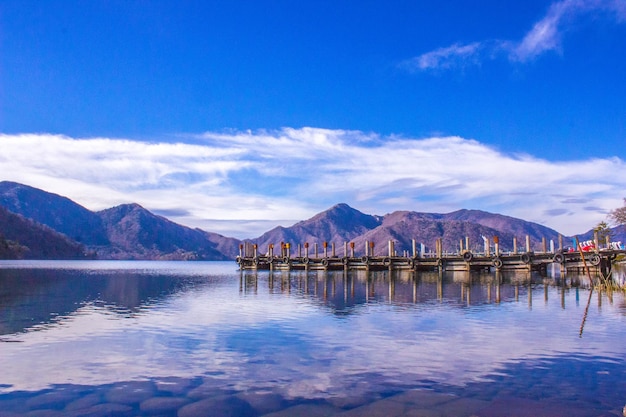 写真 青い空に囲まれた山脈の静かな湖