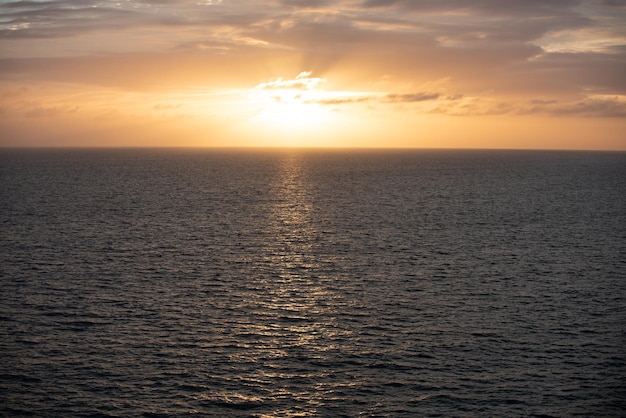 Calma acqua oceanica tramonto dorato sul paesaggio marino con tramonto sull'oceano