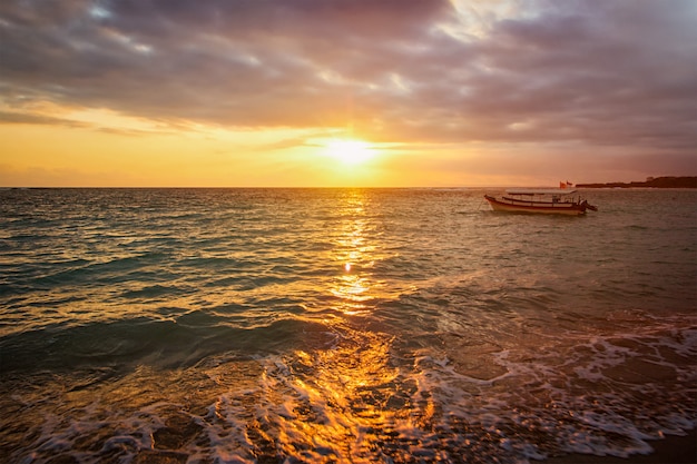 Oceano calmo con la barca su alba