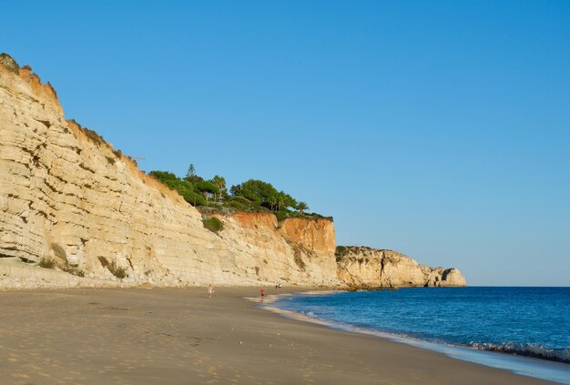 라고스 포르투갈(Lagos Portugal) 해안의 황금빛 일몰이 비추는 선명한 색상의 고요한 해양 해변