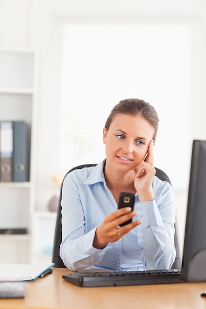 Photo calm office working holding her cellphone