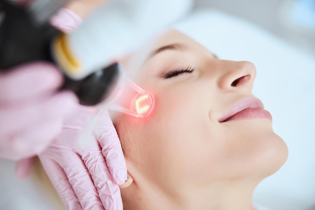 Photo calm pleased lady undergoing a cosmetic procedure