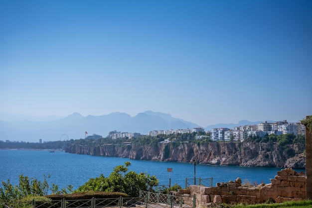 Mare calmo sullo sfondo montagne nebbiose e concetto di viaggio cielo blu