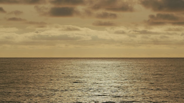 Спокойная поверхность моря Удивительный закат над тропическим пляжем Абстрактный фон мерцает на водных волнах