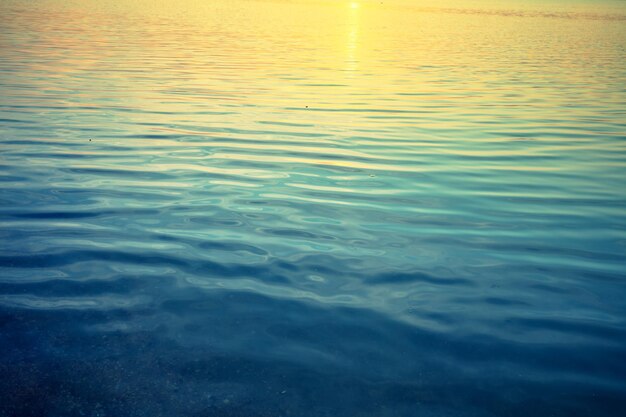 Photo calm sea surface at sunset